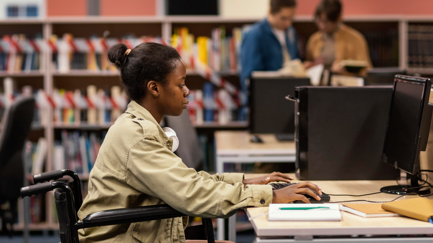 jovem negra, cadeirante, usando um computador